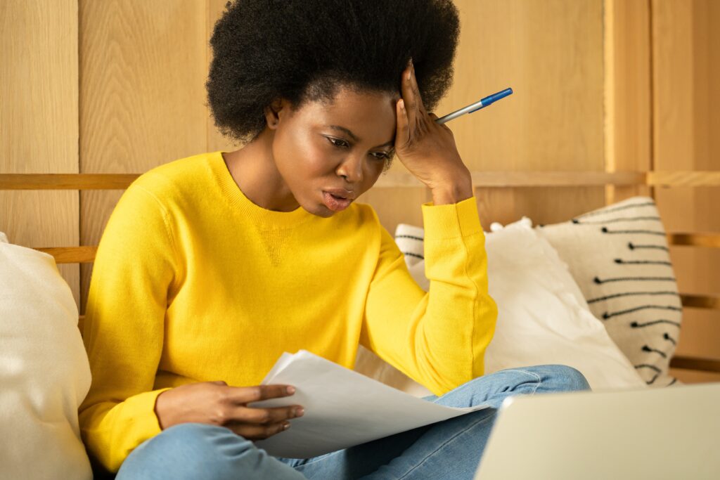 Mujer negra infeliz leyendo noticias negativas sobre aviso de desalojo